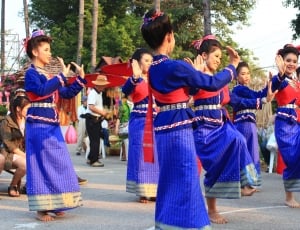 group of woman wearing blue and red long sleeve dress dancing thumbnail