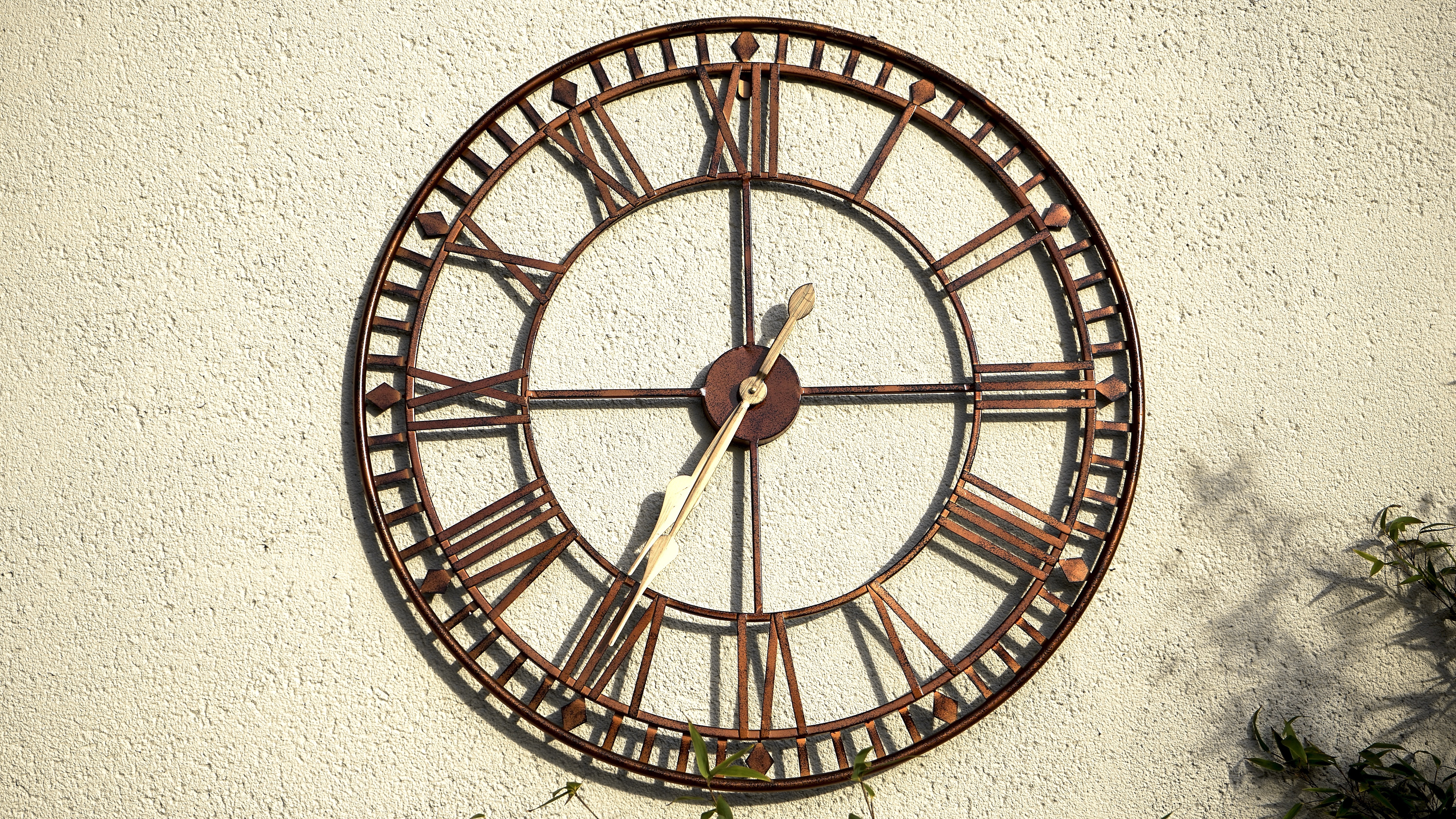 brown and gray roman numerals analog wall clock