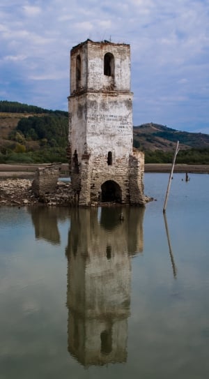 grey and white stone tower beside body of water thumbnail