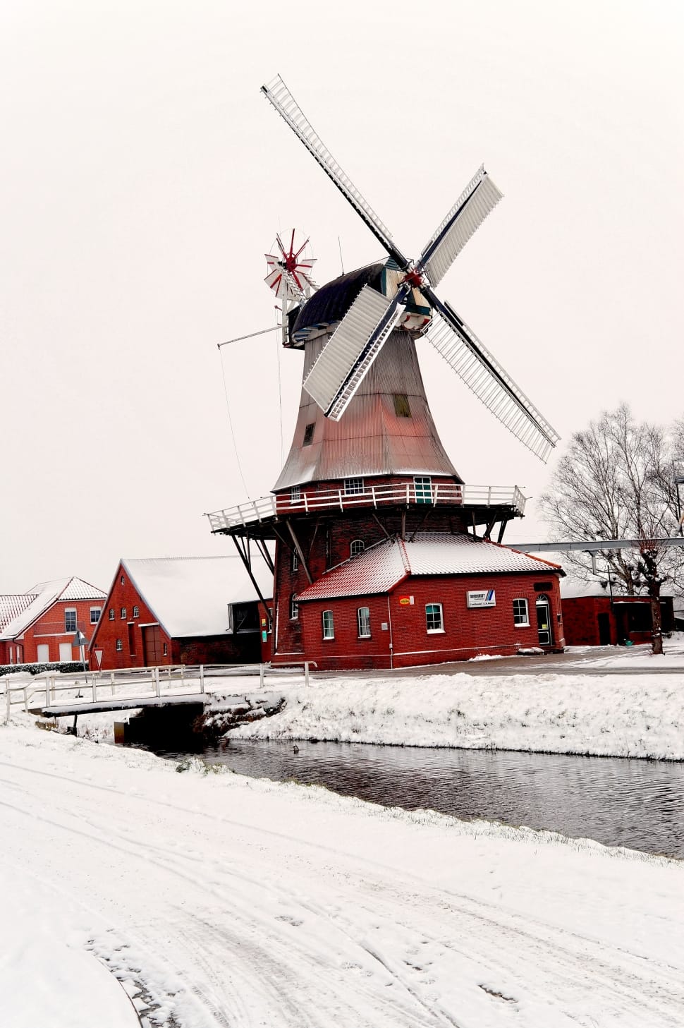 red and gray windmill near bridge during winter preview