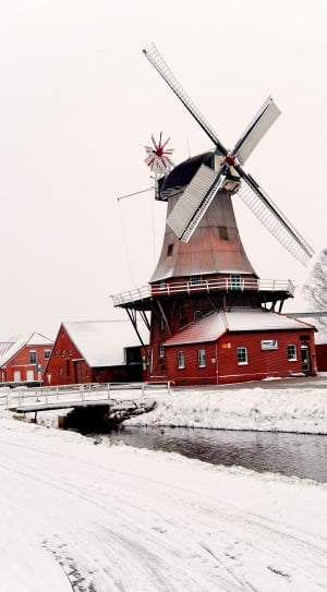 red and gray windmill near bridge during winter thumbnail