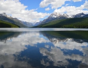 reflection of mountain and clouds on water thumbnail