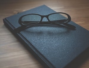 black framed eyeglasses and book thumbnail