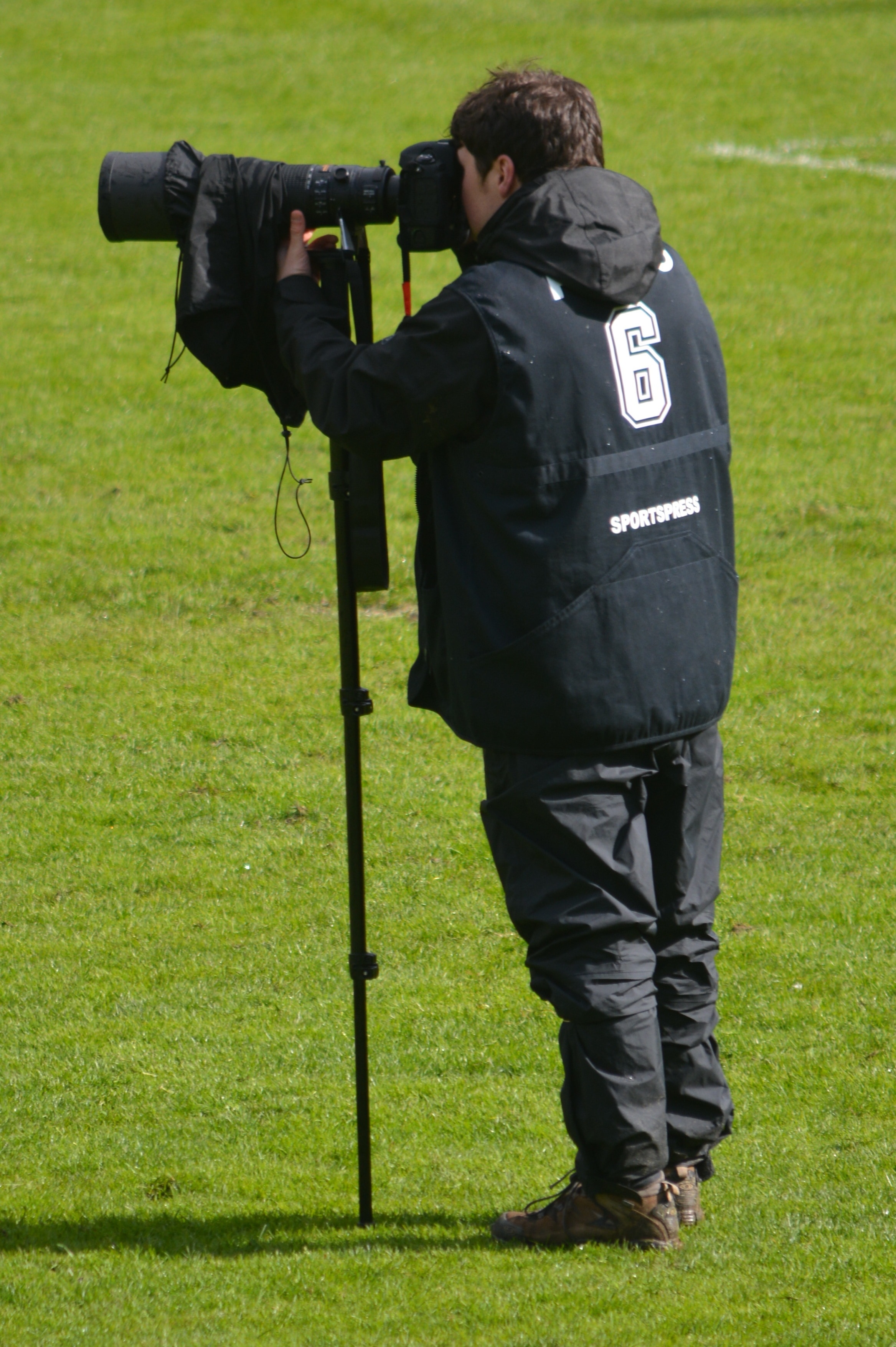 men's windbreaker hoodie and black pants and black dslr camera
