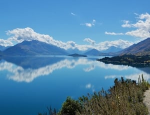 photograph of mountain besides body of water during daytime thumbnail
