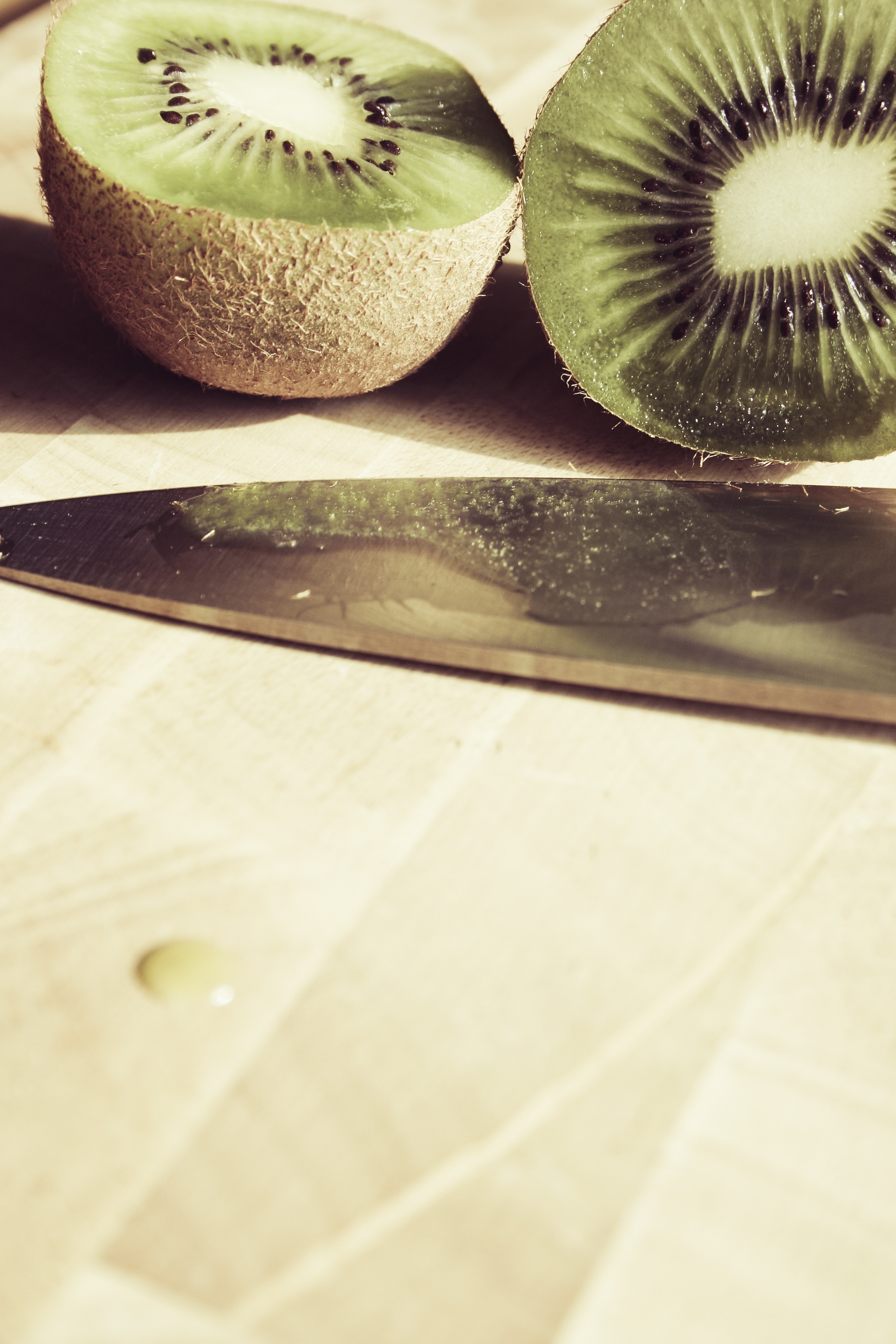 slice of kiwi and gray steel knife