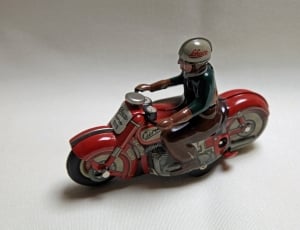 red and white man riding sports bike figurine thumbnail