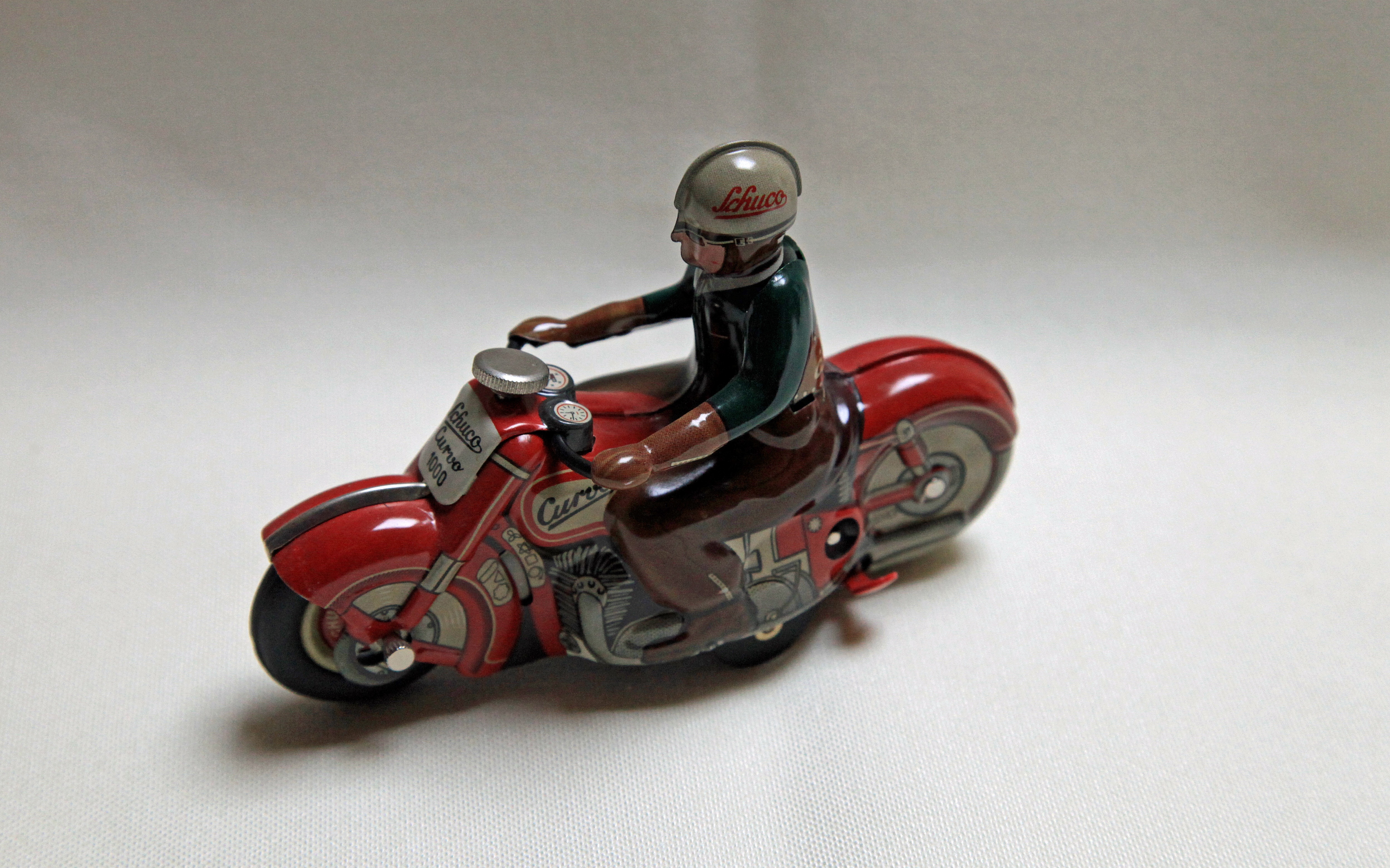 red and white man riding sports bike figurine