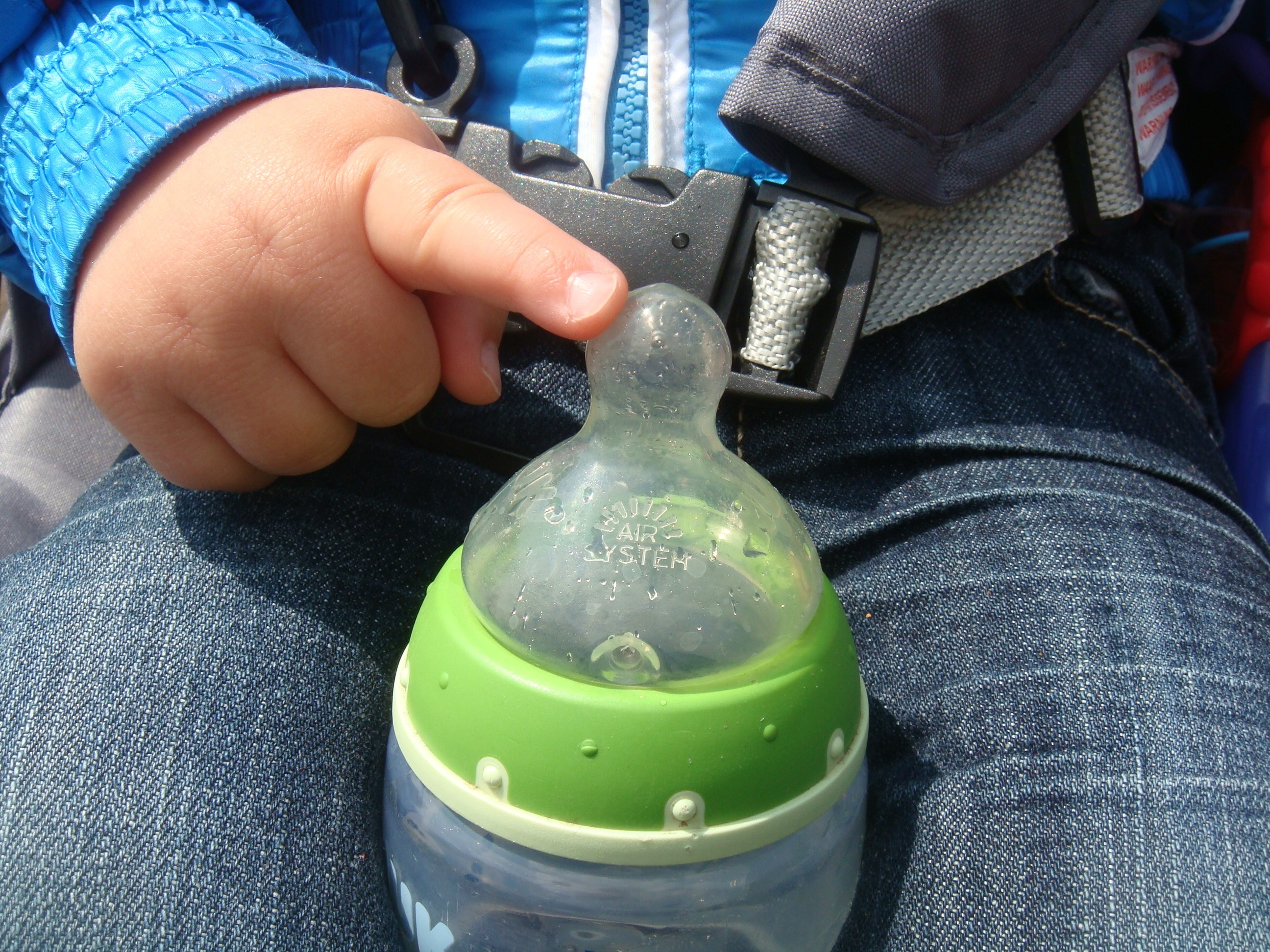 baby's white and green feeding bottle