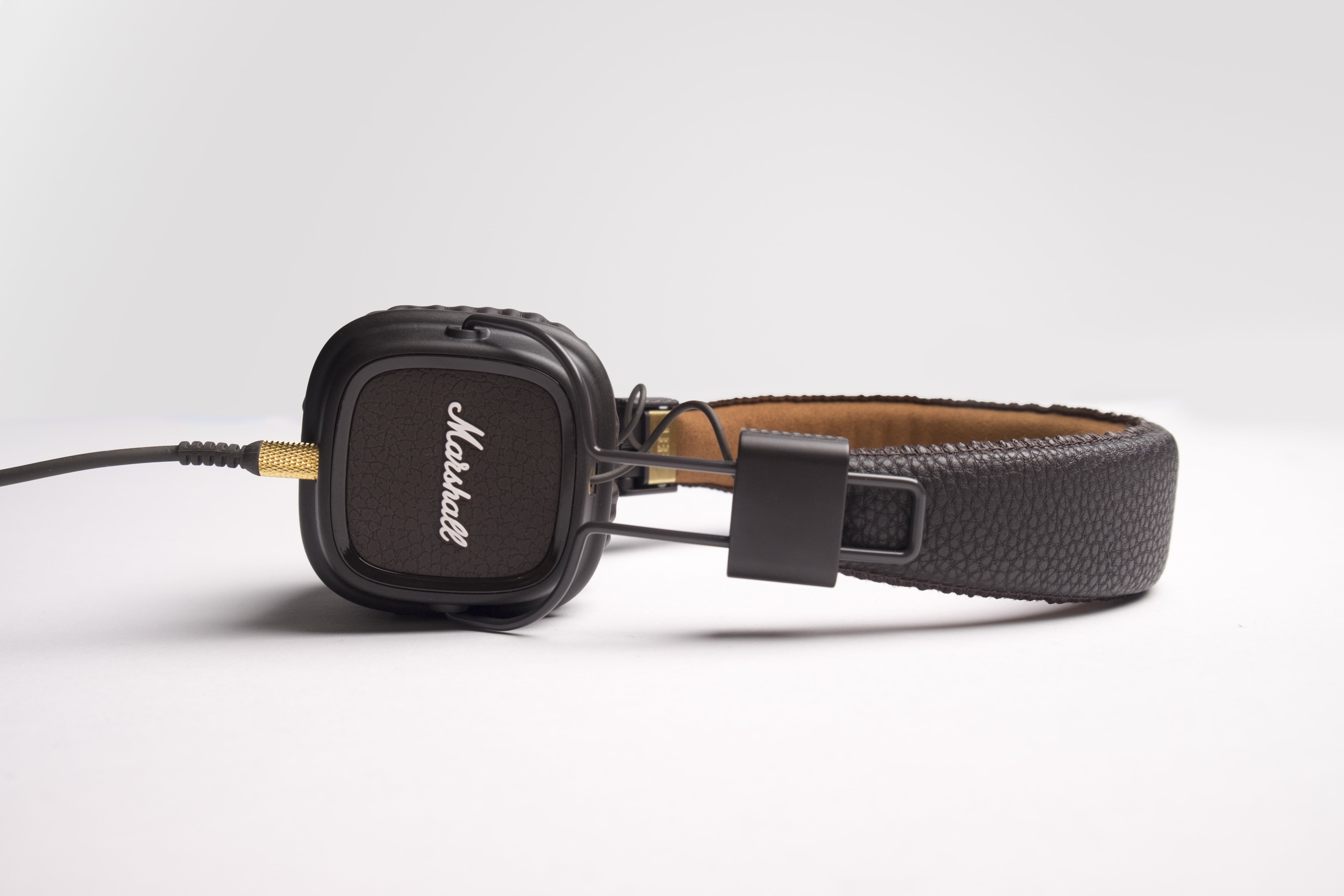 black Mashall corded headphone on white surface