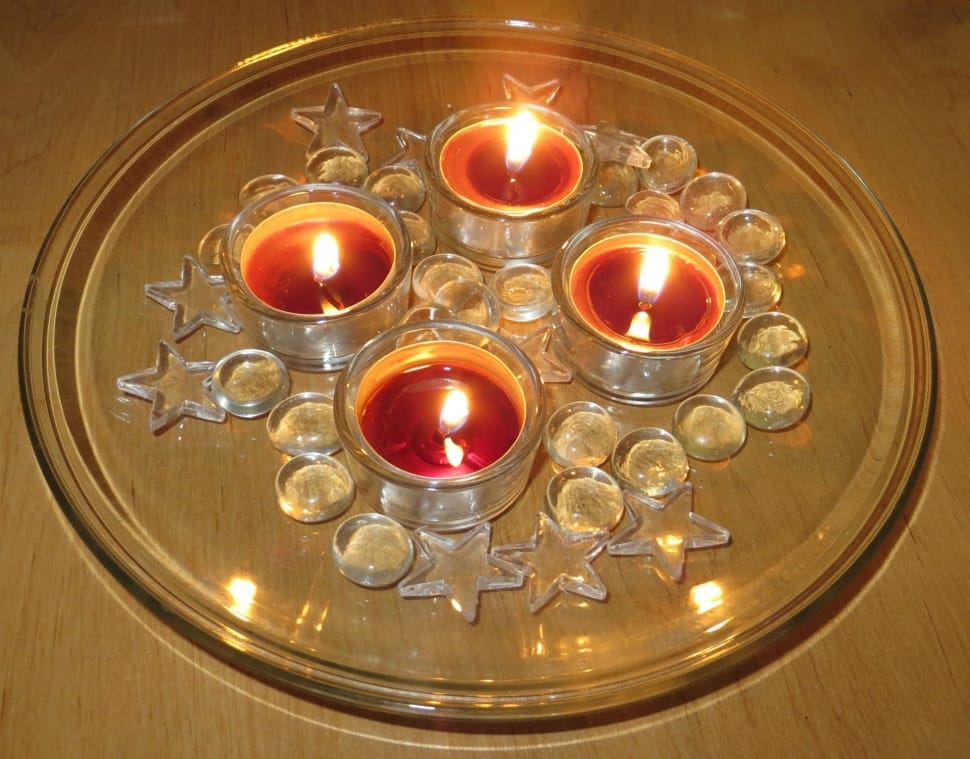 four red tealights candles on top of clear round glass tray preview