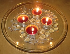 four red tealights candles on top of clear round glass tray thumbnail