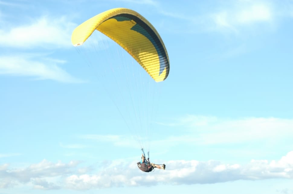 person in green shirt paragliding during daytime preview