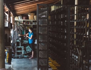 woman in blue shirt and black pants in black wooden rack room thumbnail