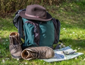 teal and blue backpack hat and brown leather hiking boots thumbnail