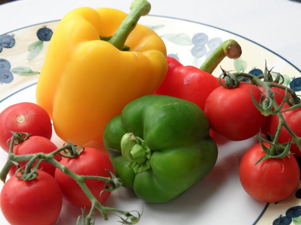 yellow red and green bell peppers with tomatoes  on white and blue ceramic plate preview