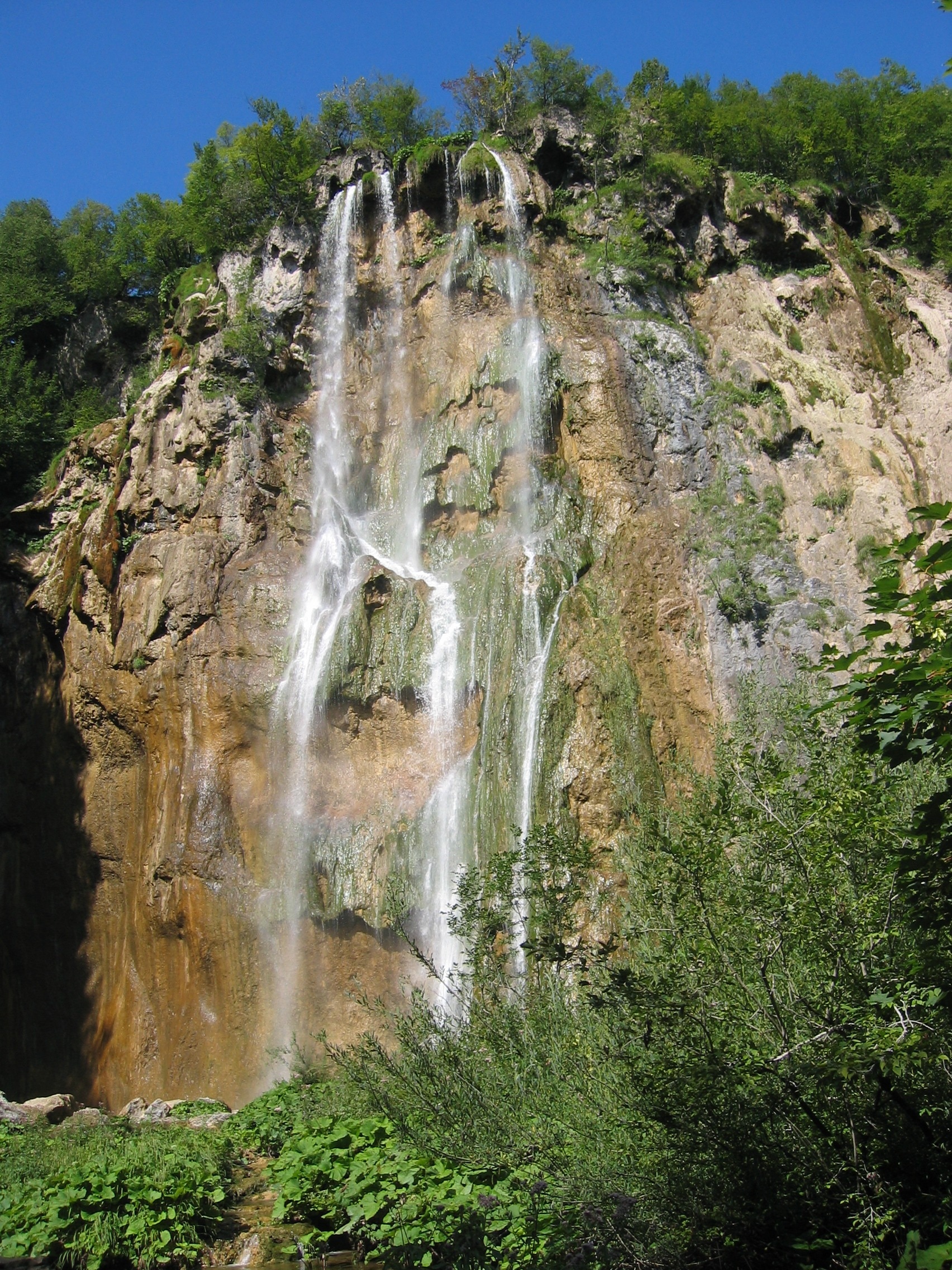 falls coming from mountain during day time