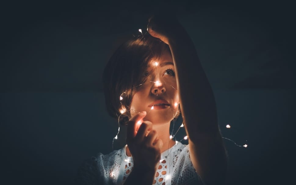 woman in gray shirt with string lights preview