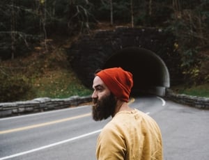 man wearing orange knit hat and yellow crew neck t-shirt waiting for a ride thumbnail