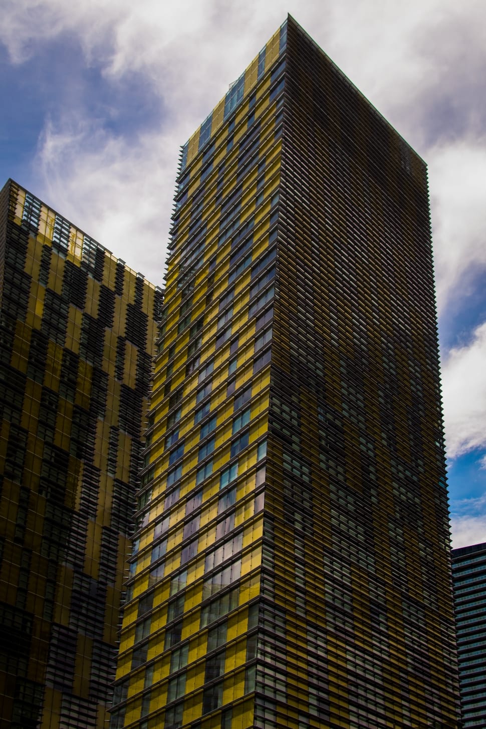 low angle photography of yellow and blue glass curtain high rise buildings at daytime preview