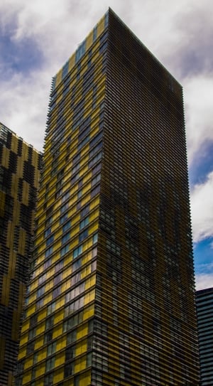 low angle photography of yellow and blue glass curtain high rise buildings at daytime thumbnail