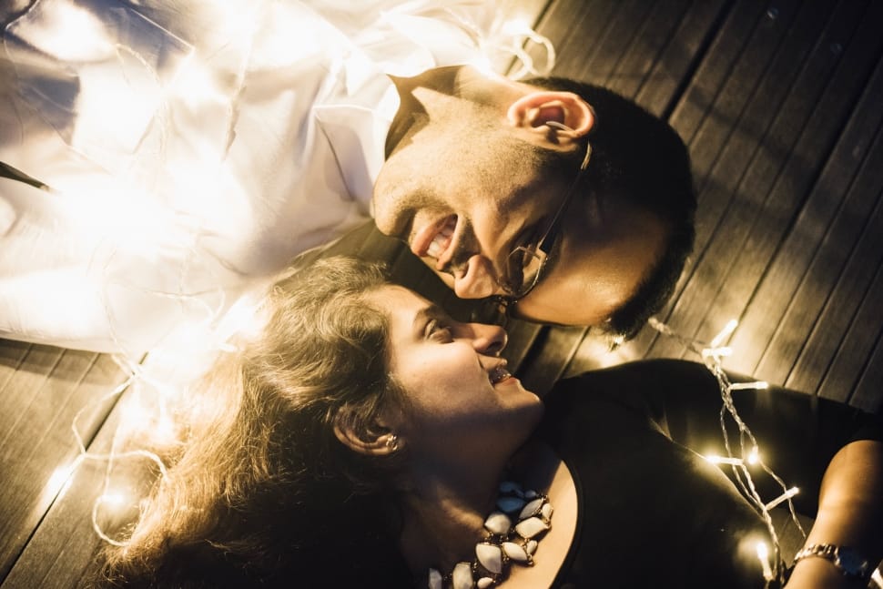 couple lying with white string lights preview