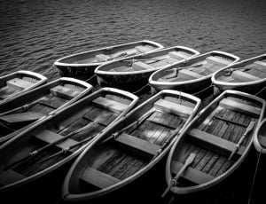 greyscale photo of row boats on body of water thumbnail