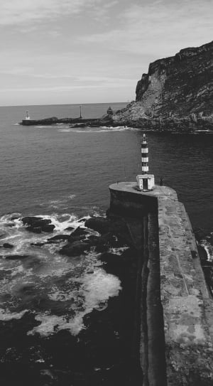 greyscale photo of lighthouses and wavy sea thumbnail