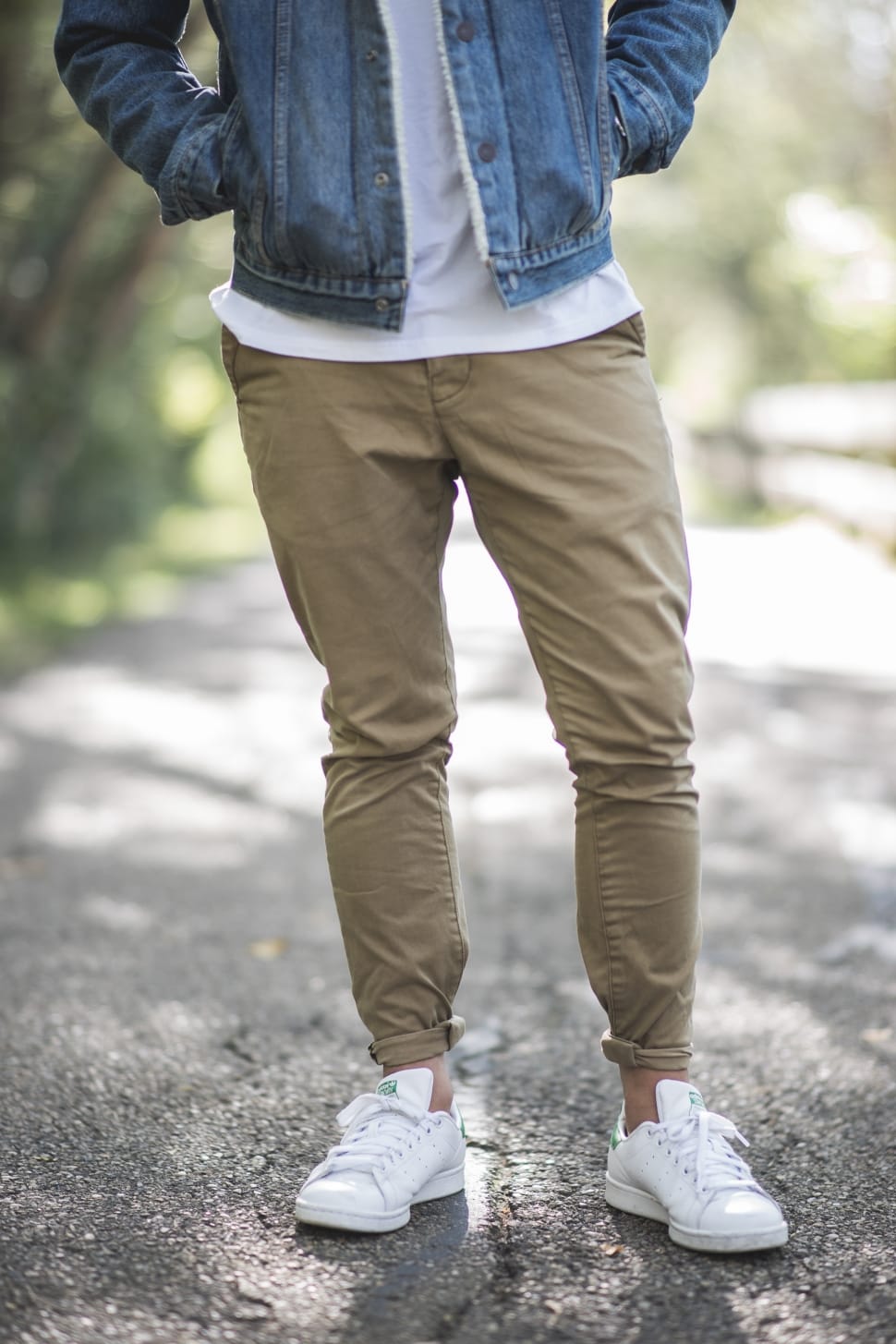 a young man wearing brown pants and a white shirt Stock Photo by Icons8