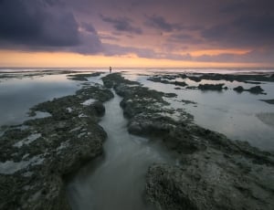 stone formations in water during sunset thumbnail