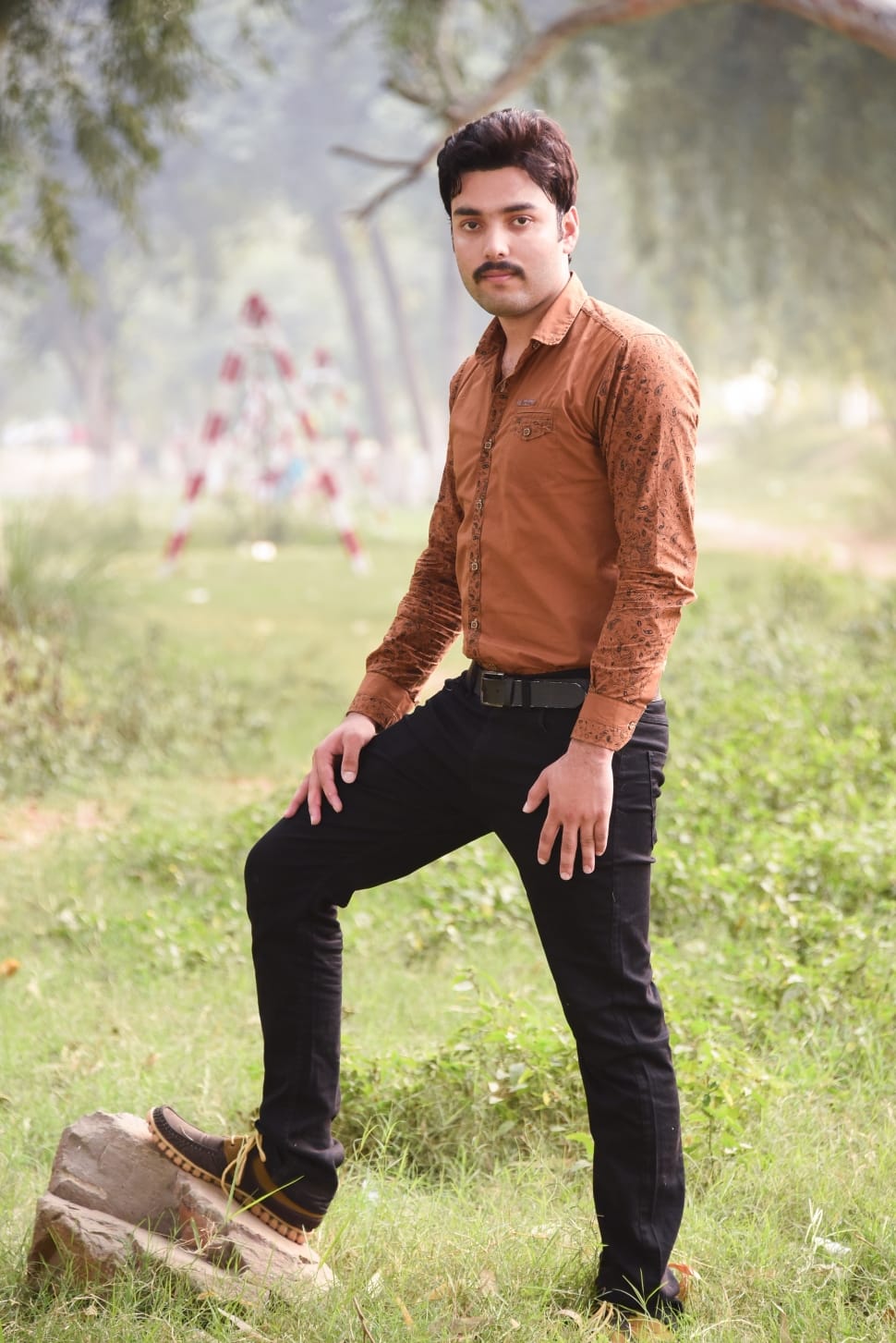 Man in brown dress shirt and black pants standing under tree during daytime  photo  Free Uttar pradesh Image on Unsplash