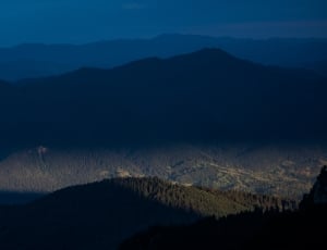 tree covered mountains during sunset thumbnail