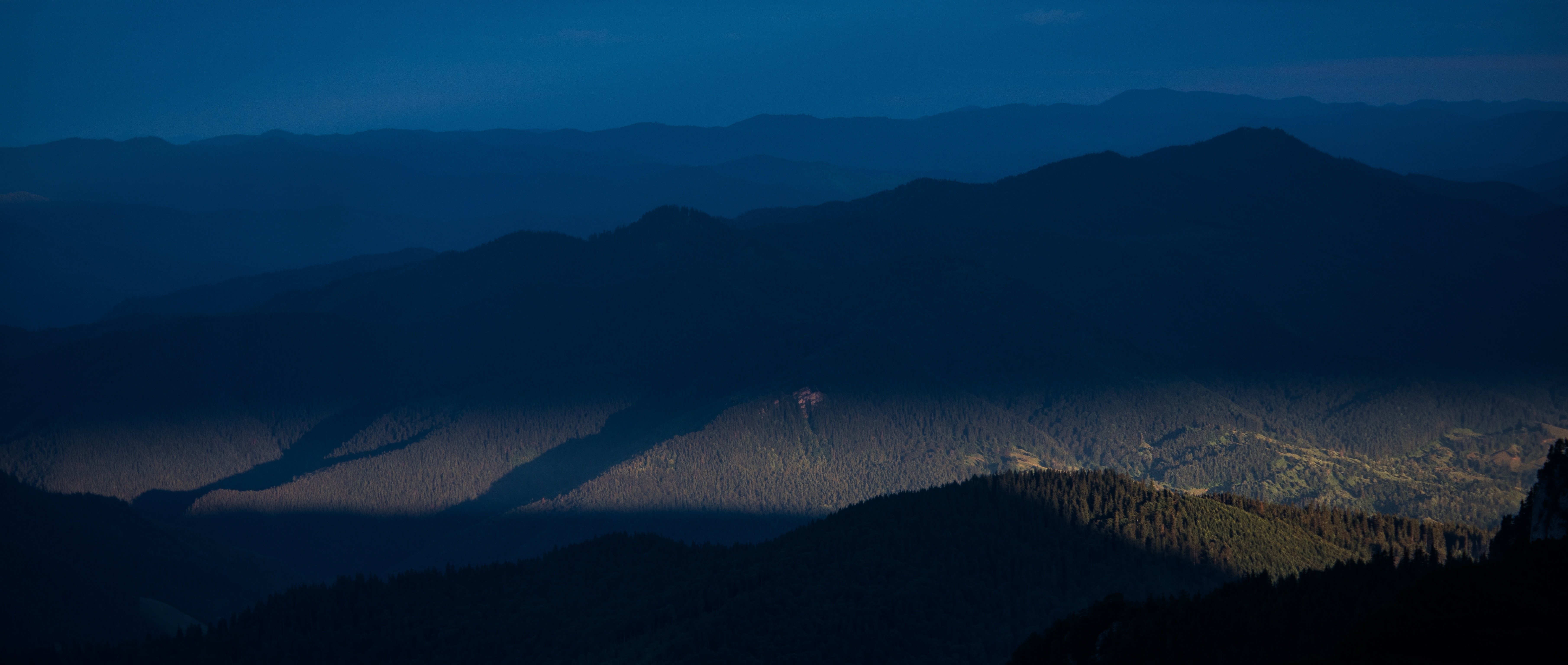 tree covered mountains during sunset