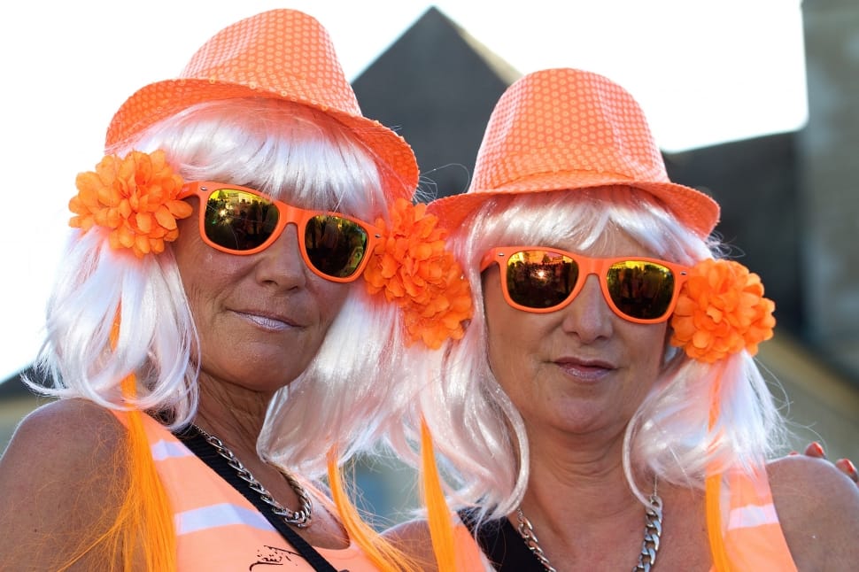 two orange fedora hats two orange wayfarer style sunglasses and two orange tank tops preview