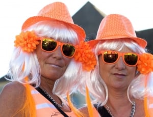 two orange fedora hats two orange wayfarer style sunglasses and two orange tank tops thumbnail