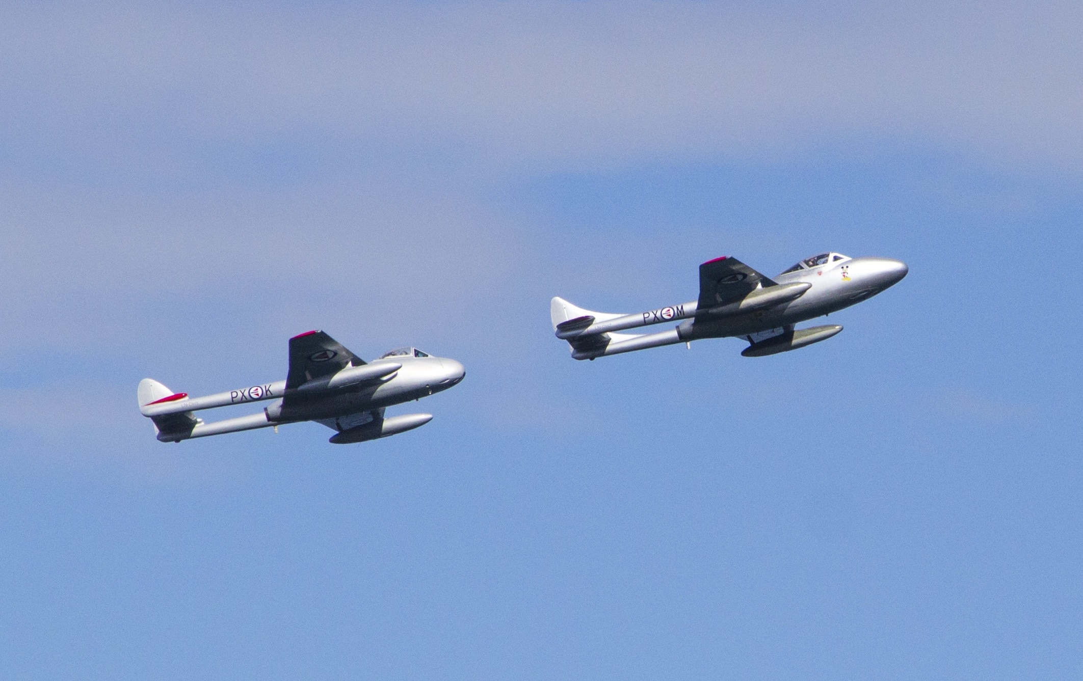 low angle photo of two grey fighter planes in flight