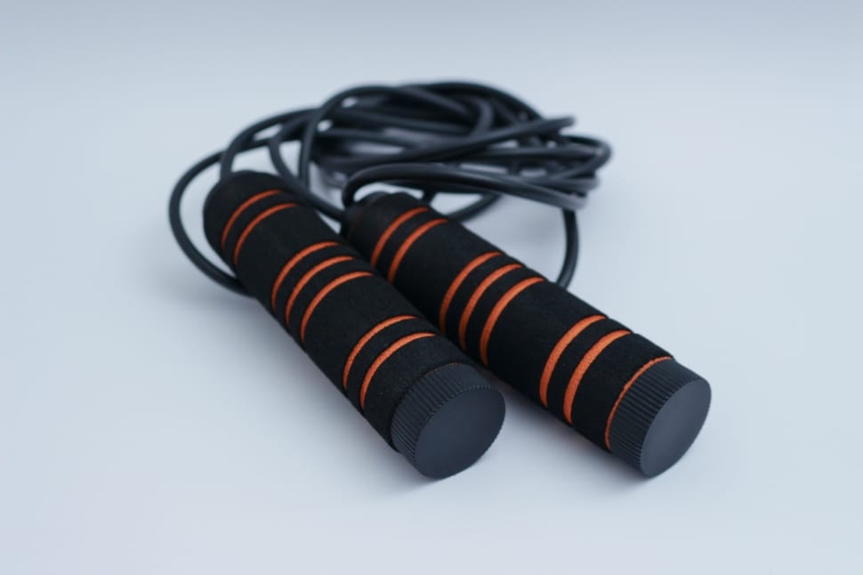 black and orange jumping rope on top of white surface preview