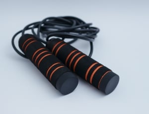black and orange jumping rope on top of white surface thumbnail