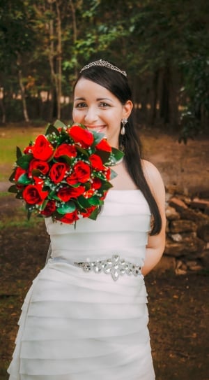 woman wearing wedding gown holding red rose bouquet thumbnail