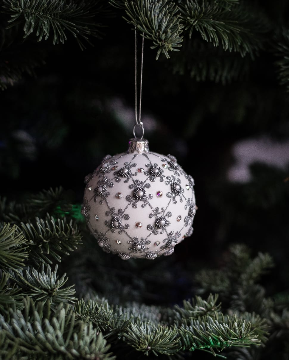 white and gray christmas baubles hanged on green tree preview