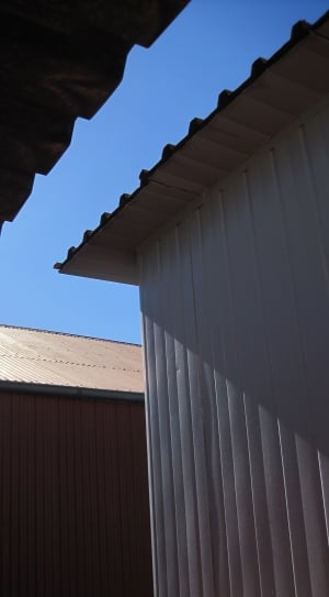 low angle photo of white metal sheds under blue sky thumbnail