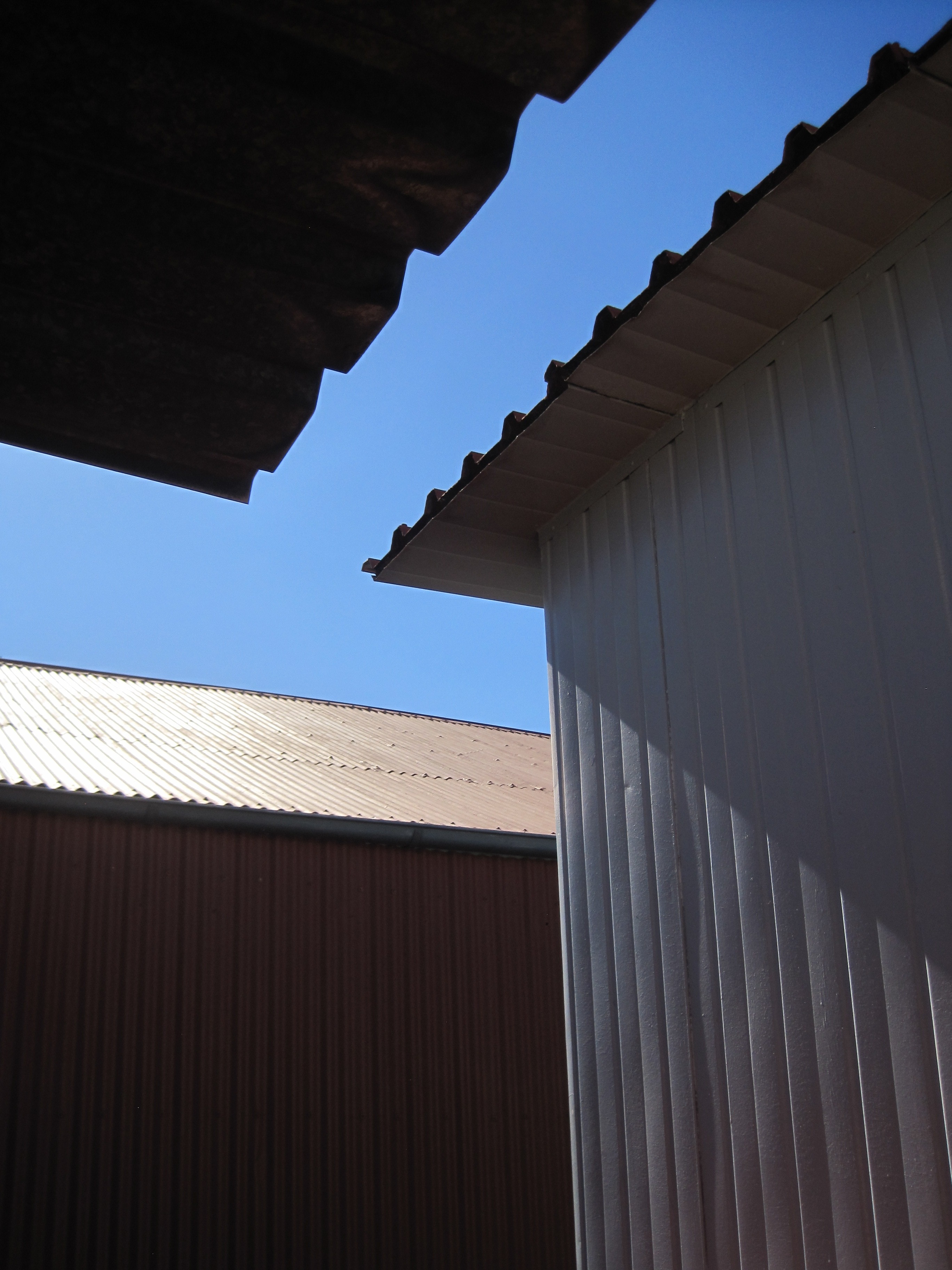low angle photo of white metal sheds under blue sky