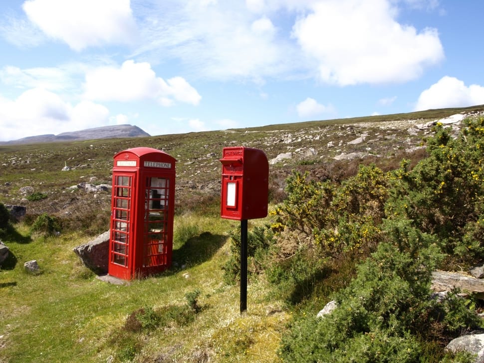 red and white phone booths on highland mountains taken during daytime preview