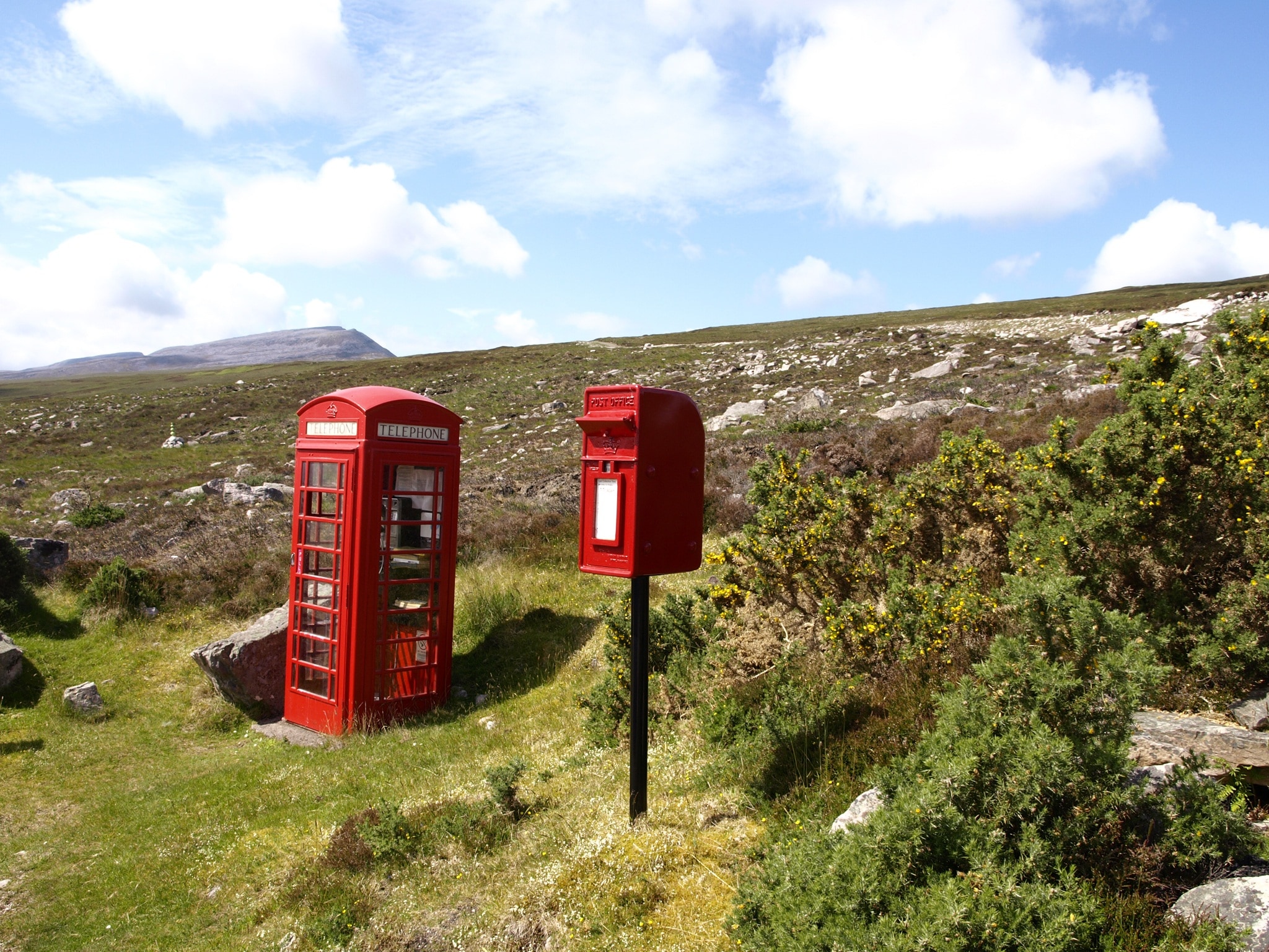 red and white phone booths on highland mountains taken during daytime