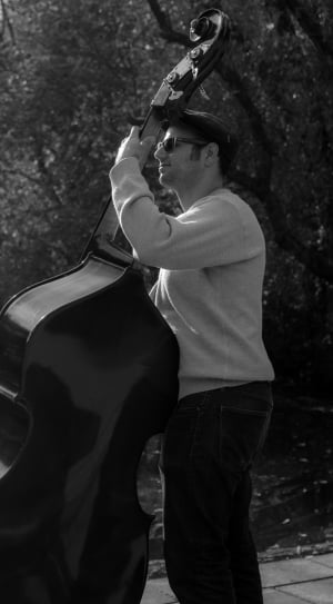 gray scale photography of man playing cello thumbnail