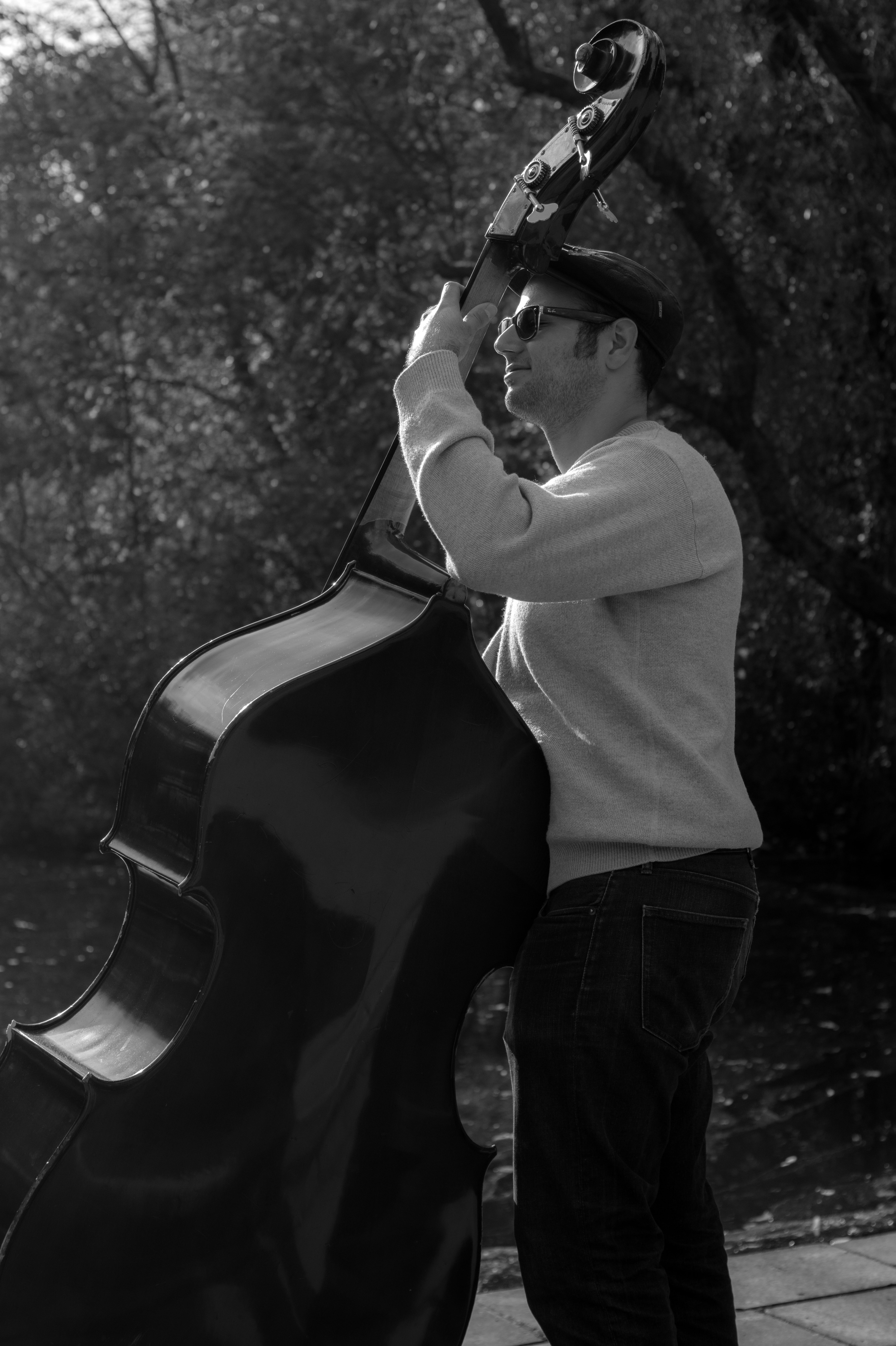gray scale photography of man playing cello