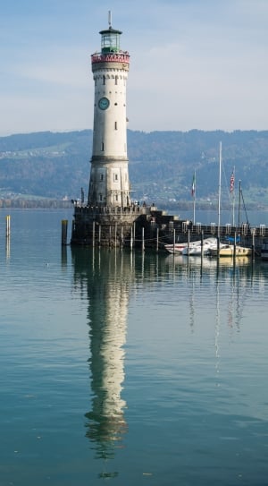 lighthouse surrounded by body of water thumbnail