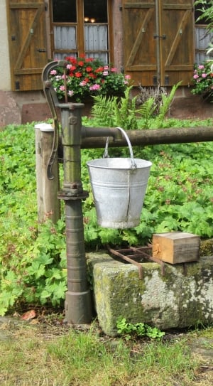 stainless steel bucket above water pump during daytime thumbnail