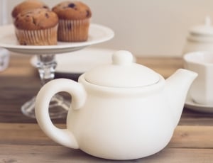 selective focus photo of white ceramic tea pot near three brown muffins on white plate thumbnail