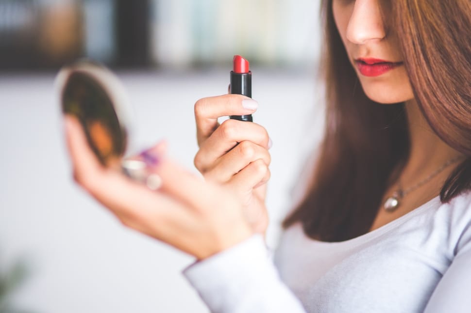 woman holding red lipstick and blush on preview